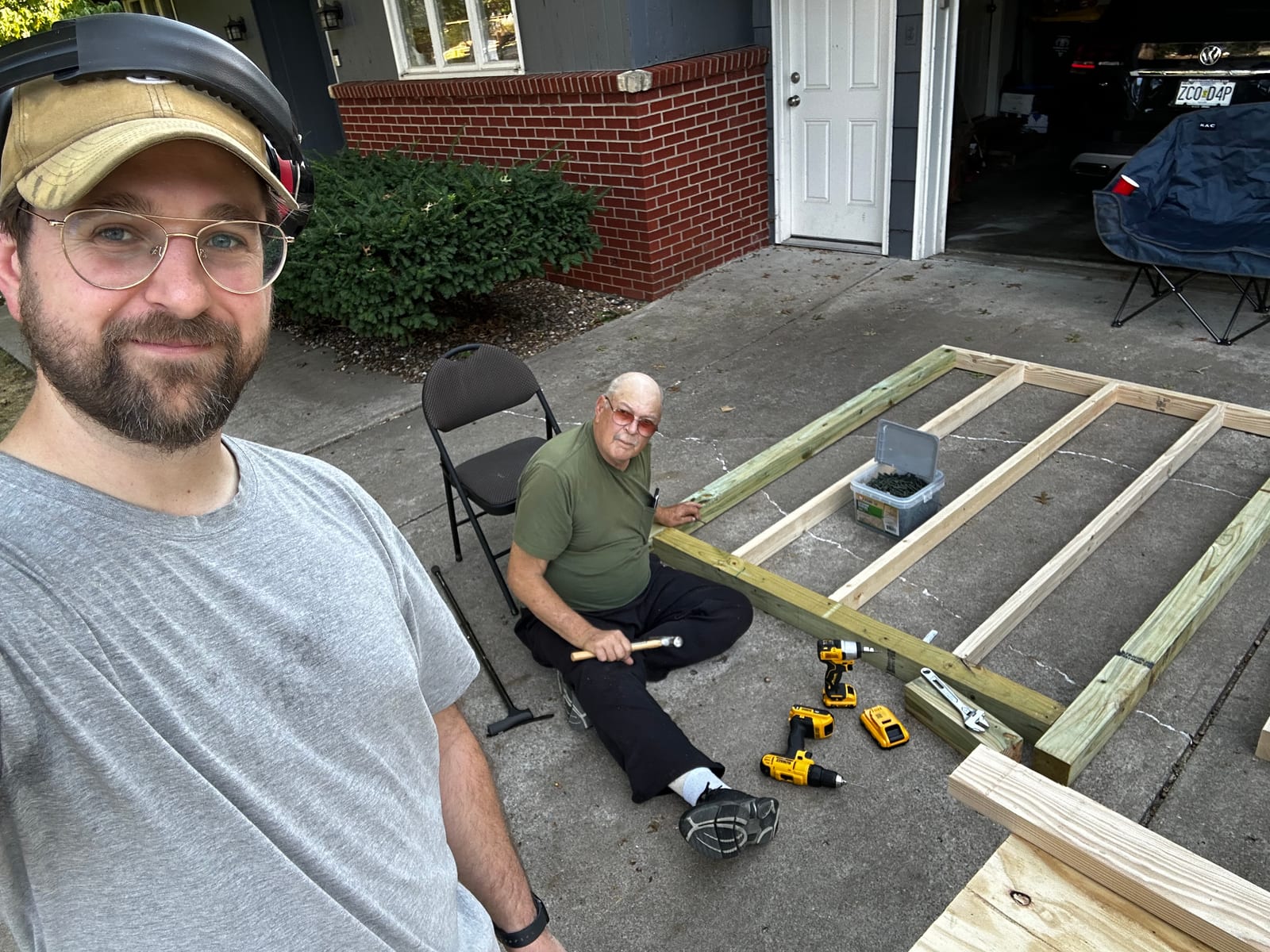 Ben and his dad beside the framed coop floor on the driveway.