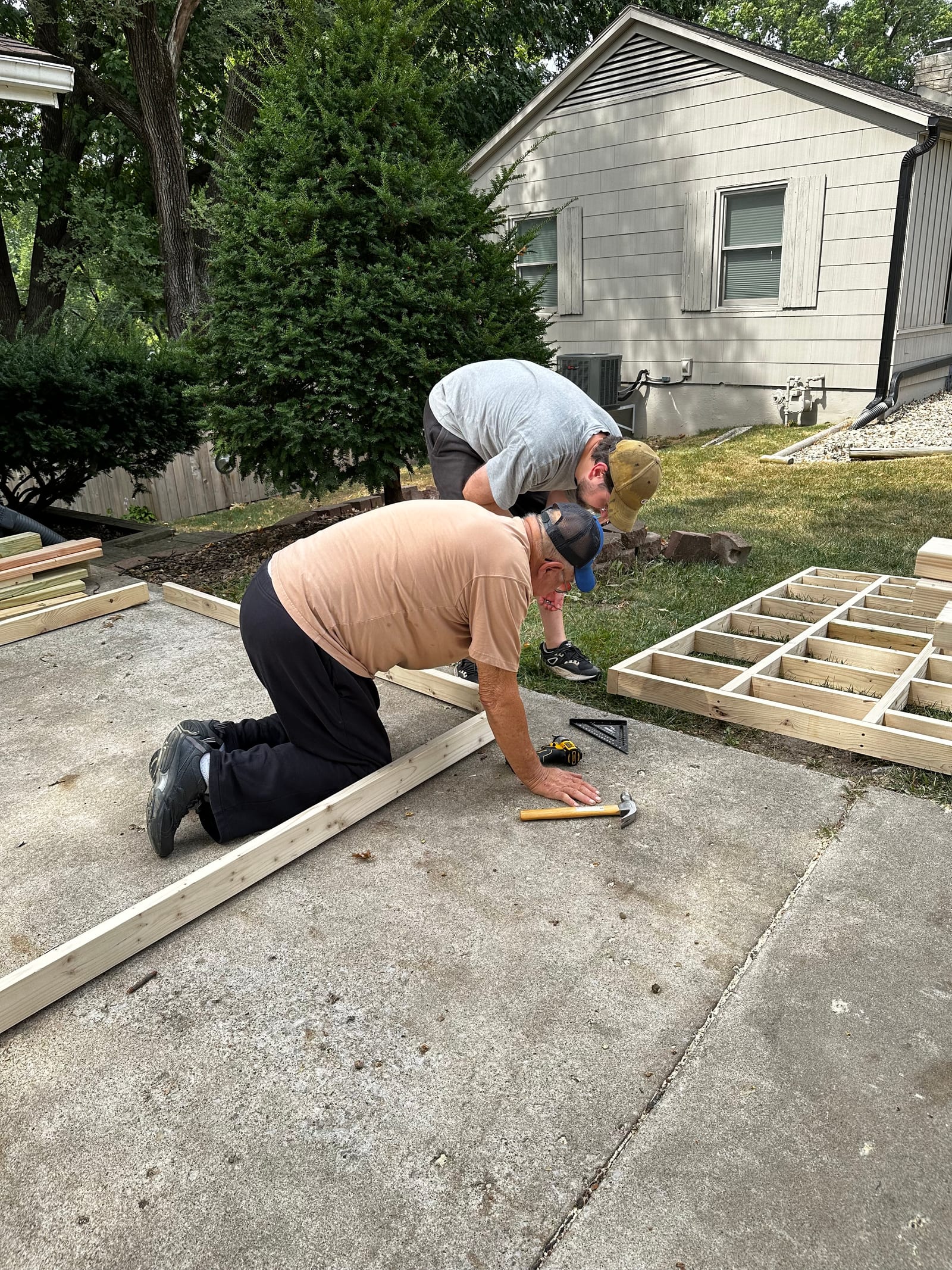 Ben and his dad kneeling together over the framing.